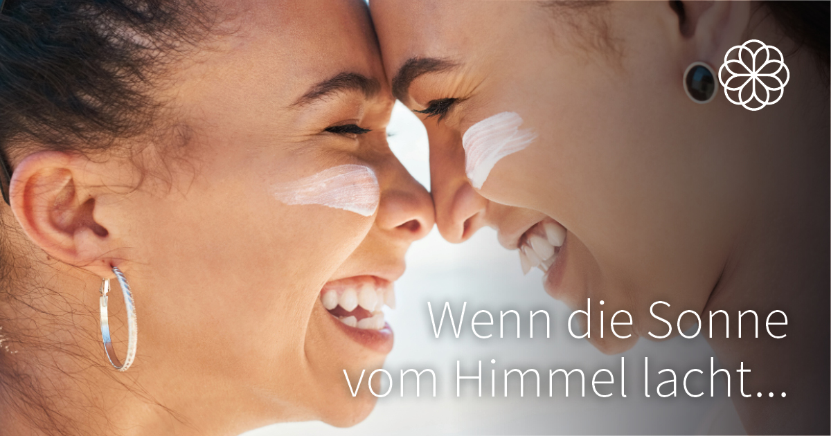 Sonnencreme wenn die Sonne lacht Zwei lachende Personen mit Sonnencreme auf der Nase berühren einander spielerisch mit der Stirn.